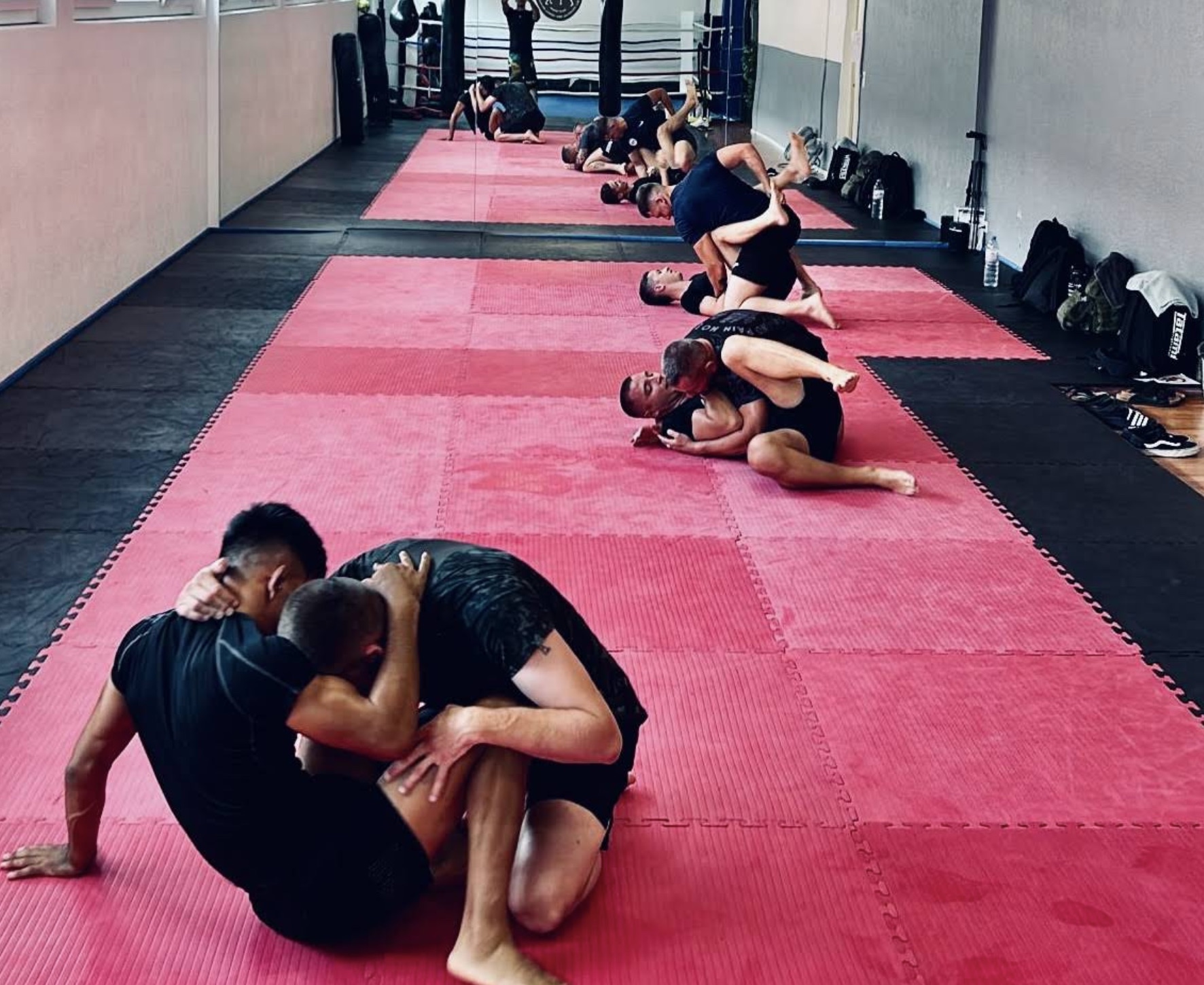 Sparring No-Gi sul tatami, allievi che lottano a coppie